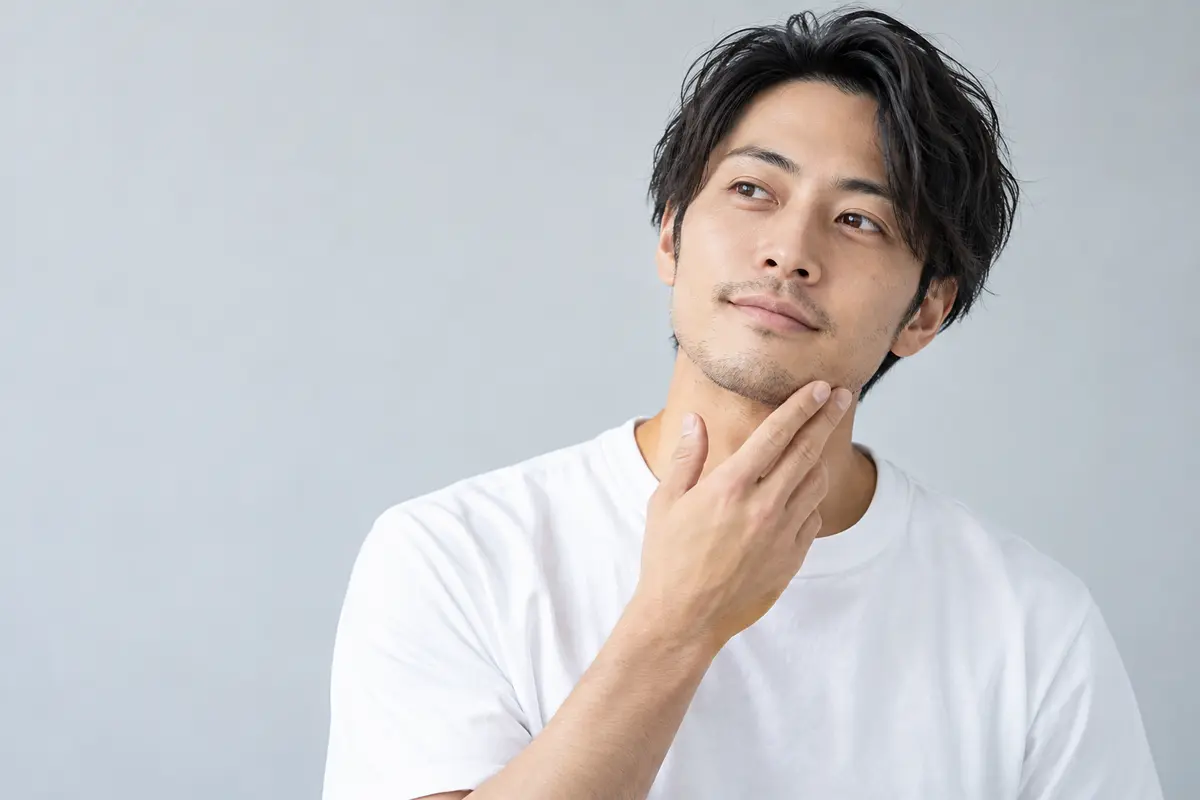 ヒゲ剃りについて考える男性モデルのイメージ